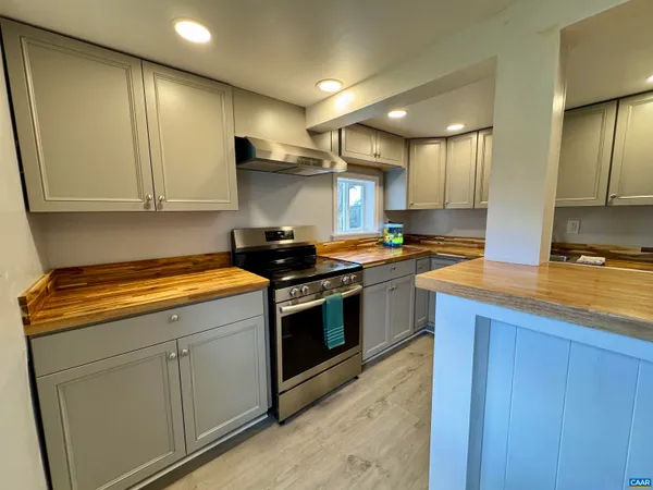 a kitchen with granite countertop a stove and cabinets