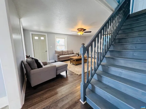 an empty room with wooden floor and a ceiling fan