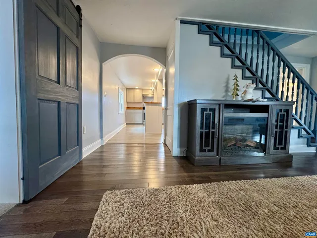 a view of a hallway with wooden floor and staircase