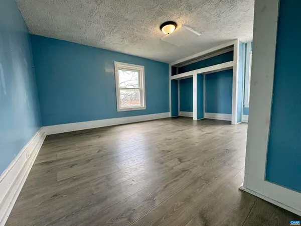 a living room with wooden floor and a chandelier