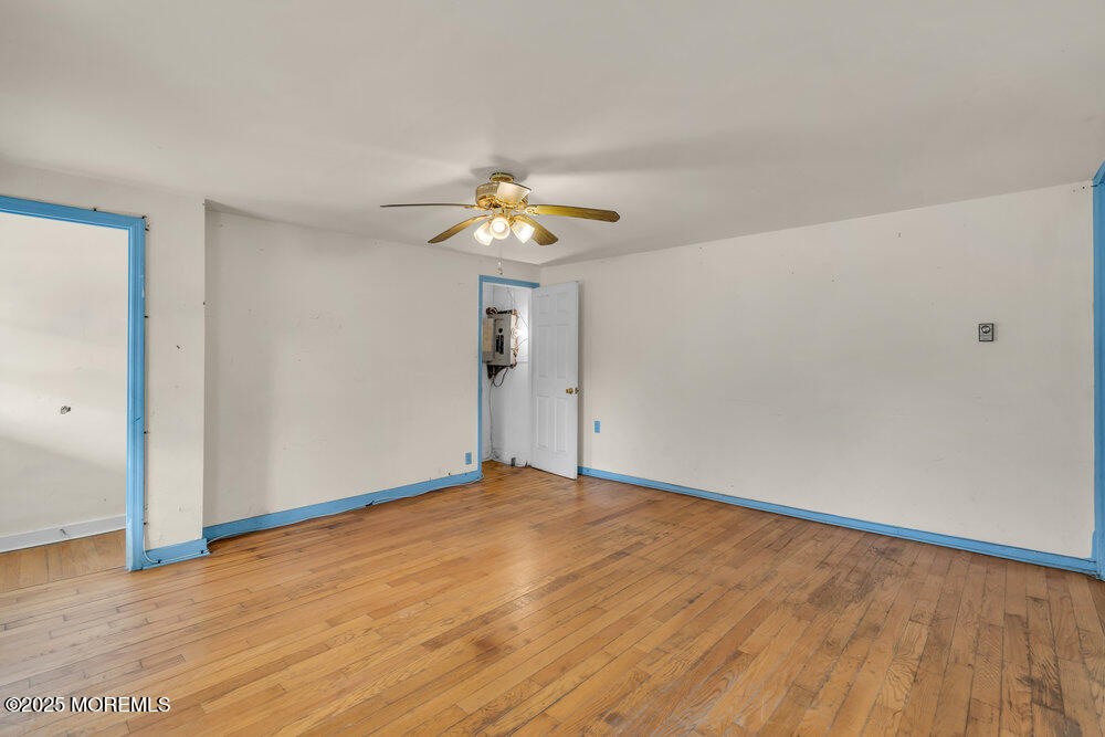22 Lacey Road Forked River, NJ 08731 - Photo 9 of 24 a view of an empty room with chandelier fan and wooden floor
