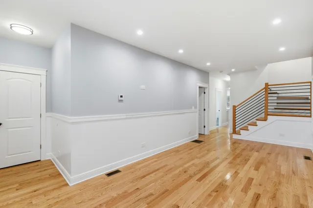 a view of an empty room with wooden floor