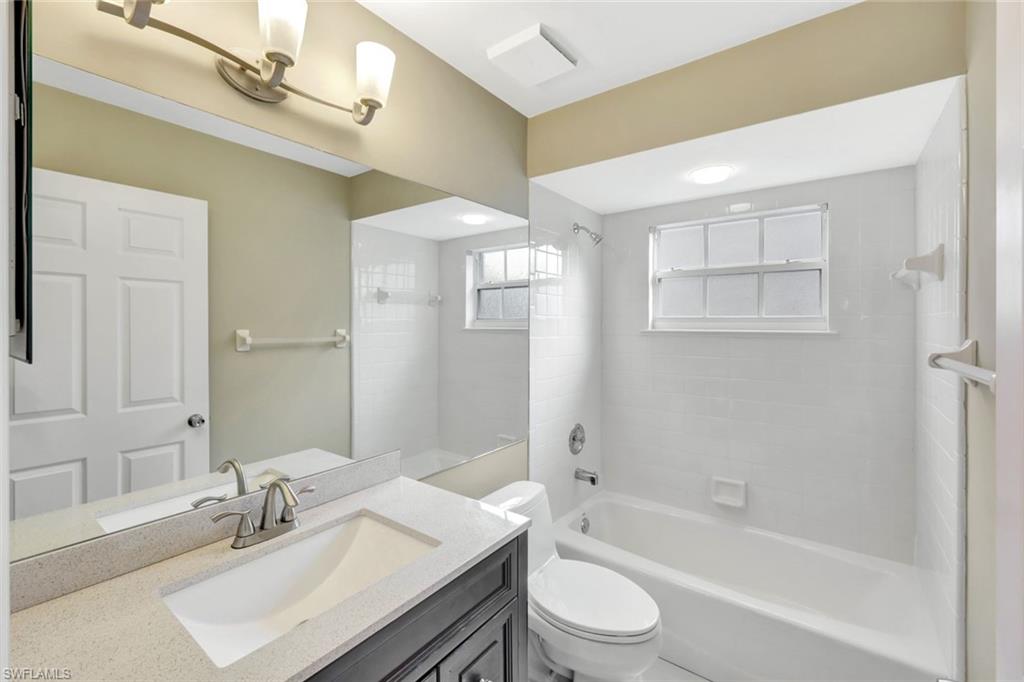 240 Via Perignon, Unit 91 Naples, FL 34119 - Photo 14 of 43 a bathroom with a granite countertop sink a toilet a mirror and bathtub