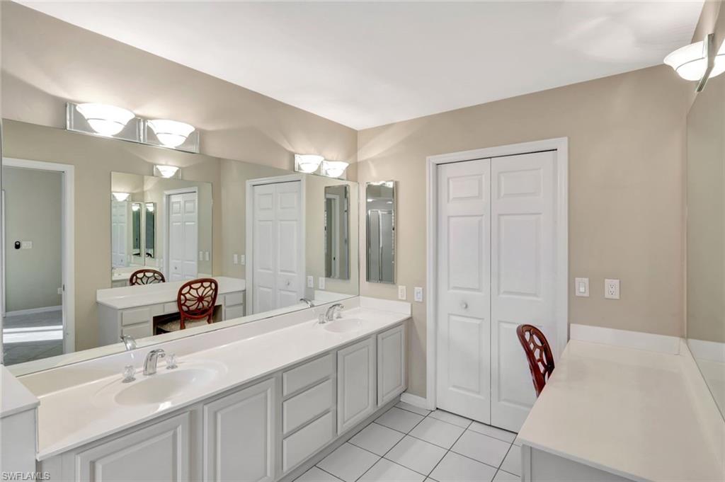 240 Via Perignon, Unit 91 Naples, FL 34119 - Photo 17 of 43 a bathroom with a double vanity sink a mirror and shower