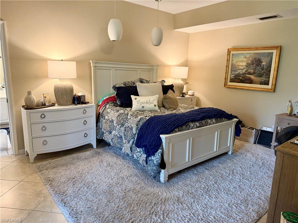 240 Via Perignon, Unit 91 Naples, FL 34119 - Photo 21 of 43 a spacious bedroom with a bed and a night stand