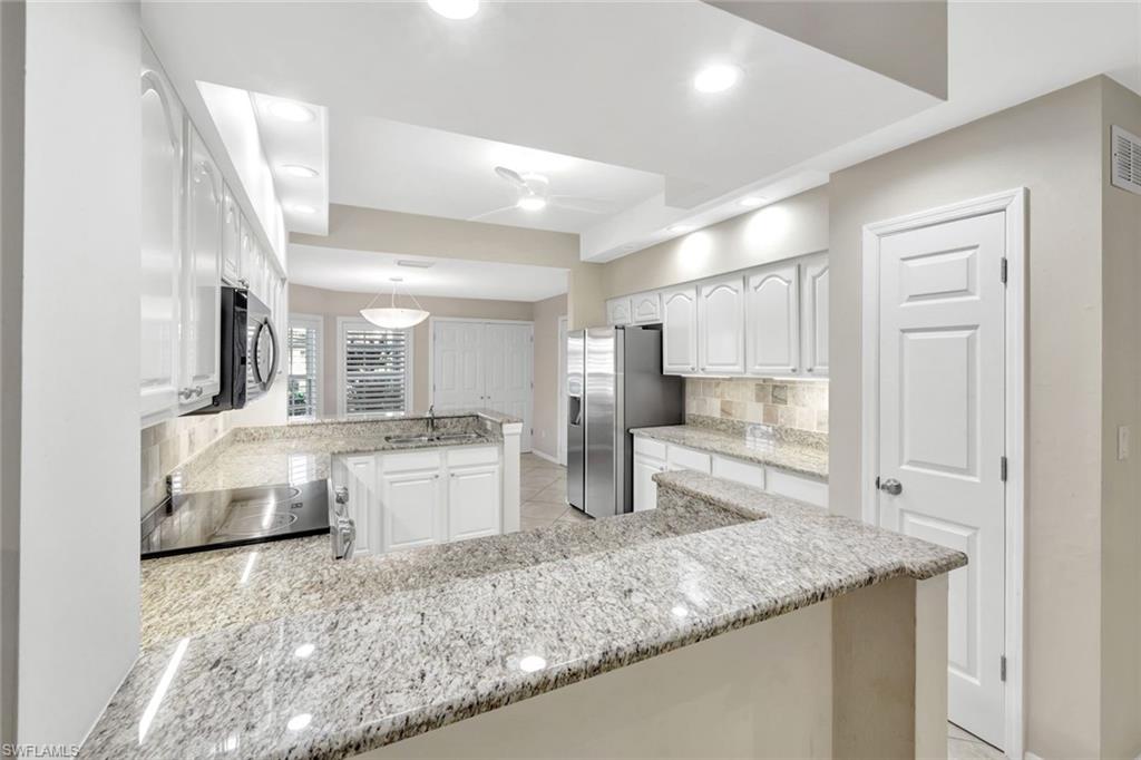 240 Via Perignon, Unit 91 Naples, FL 34119 - Photo 29 of 43 a kitchen with counter top space cabinets and stainless steel appliances