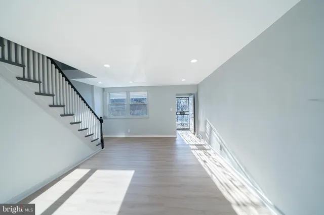 a view of a hallway with wooden floor and staircase