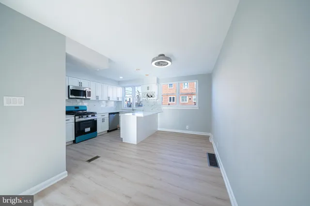 a view of a kitchen and an empty room