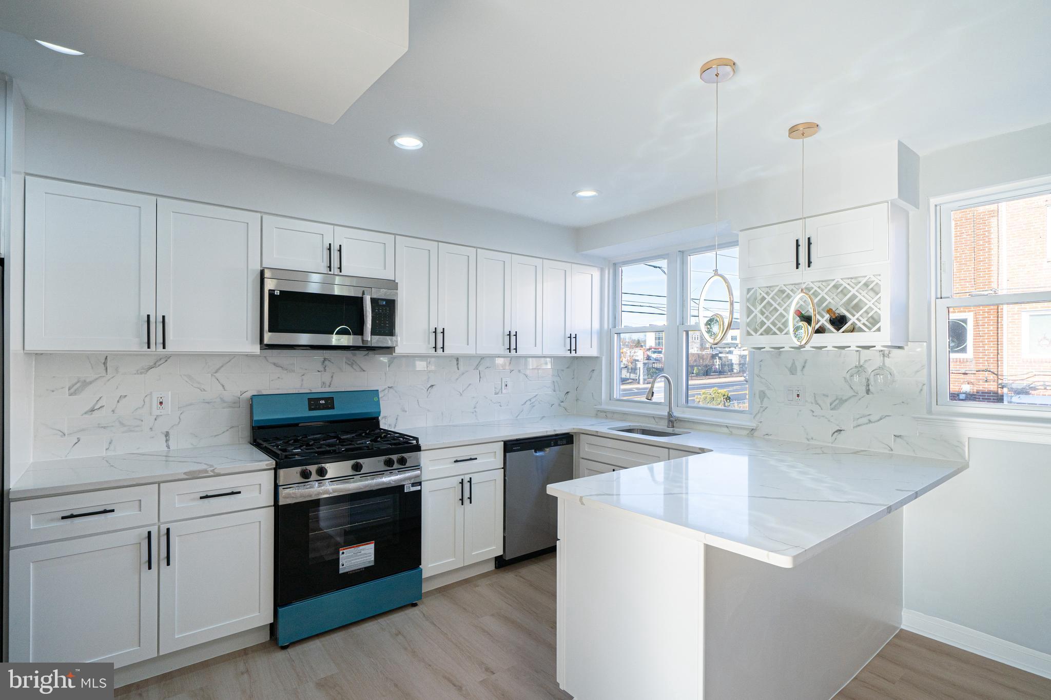 8659 Fayette Street Philadelphia, PA 19150 - Photo 22 of 47 a kitchen with stainless steel appliances white cabinets and wooden floor