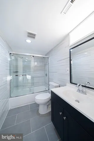 a bathroom with a double vanity sink toilet and shower