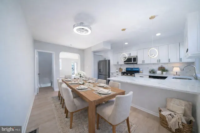 a kitchen with a dining table chairs and white cabinets