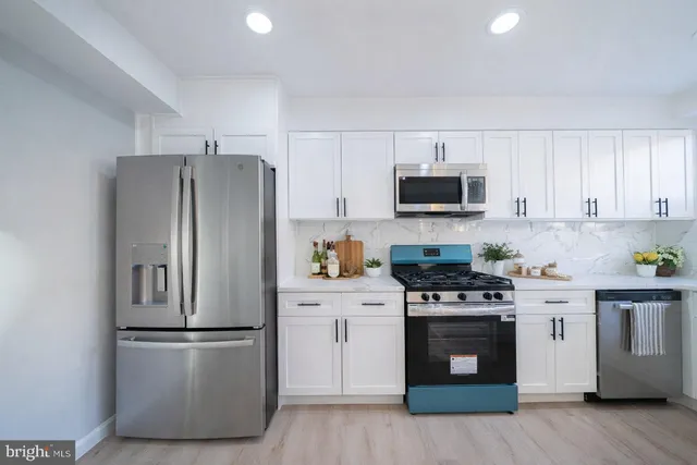 a kitchen with stainless steel appliances a refrigerator stove and microwave