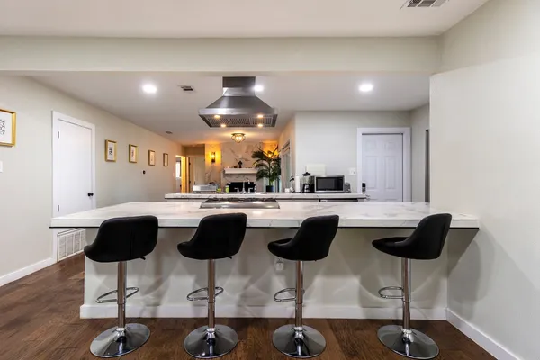 a kitchen with a dining table chairs and a granite counter top