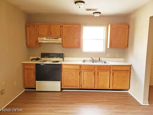 a view of kitchen with stainless steel appliances granite countertop a stove a sink and a microwave