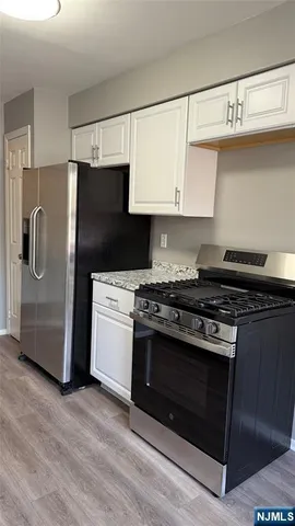a kitchen with stainless steel appliances granite countertop a stove a refrigerator and a microwave