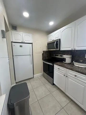a kitchen with a refrigerator a stove a microwave and cabinets