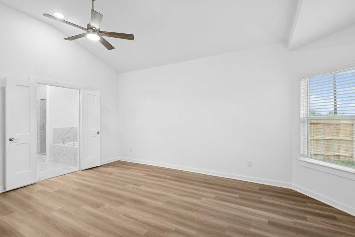 3422 Fresh Bluestream Lane Rosenberg, TX 77471 - Photo 14 of 48 an empty room with wooden floor ceiling fan and windows