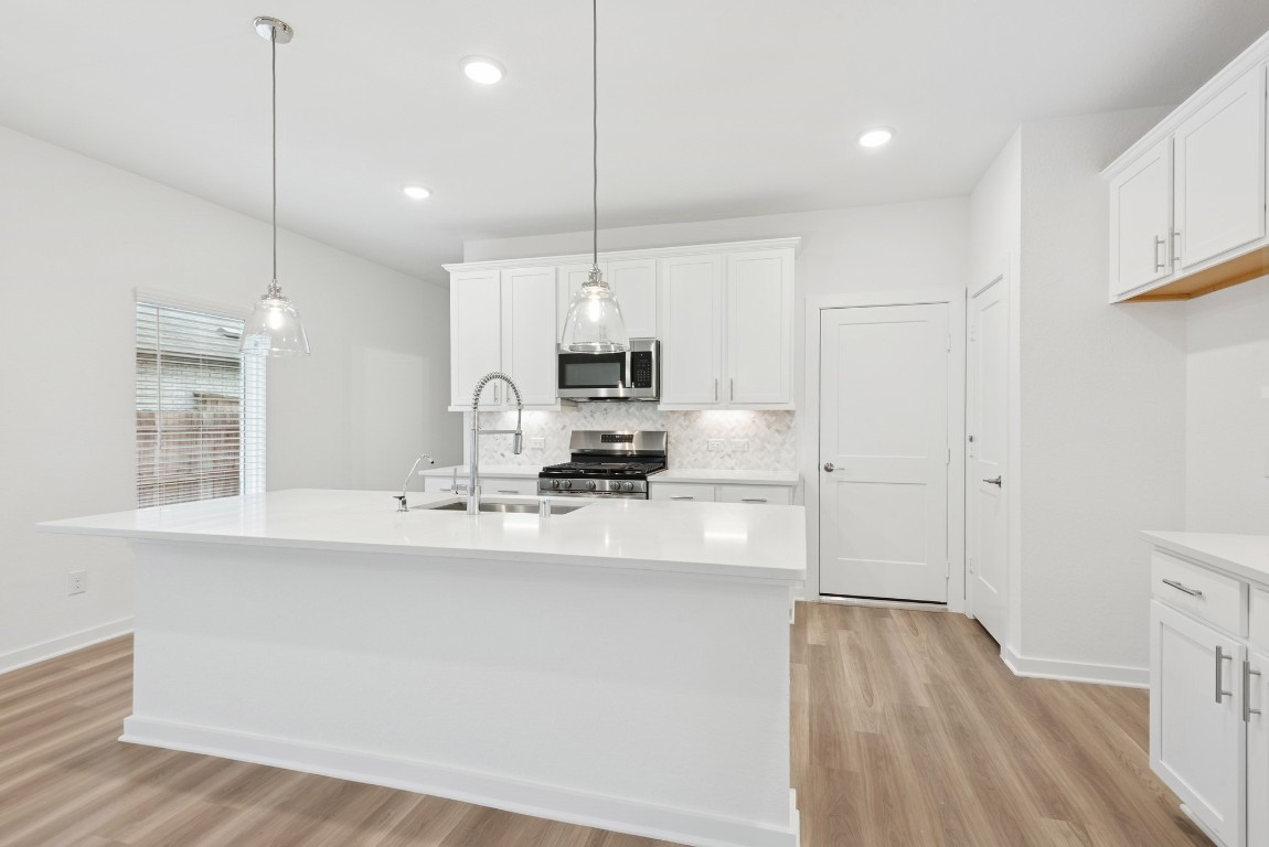 3422 Fresh Bluestream Lane Rosenberg, TX 77471 - Photo 23 of 48 a kitchen with kitchen island a sink stainless steel appliances and cabinets