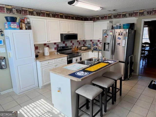 a kitchen with stainless steel appliances a stove refrigerator sink and microwave