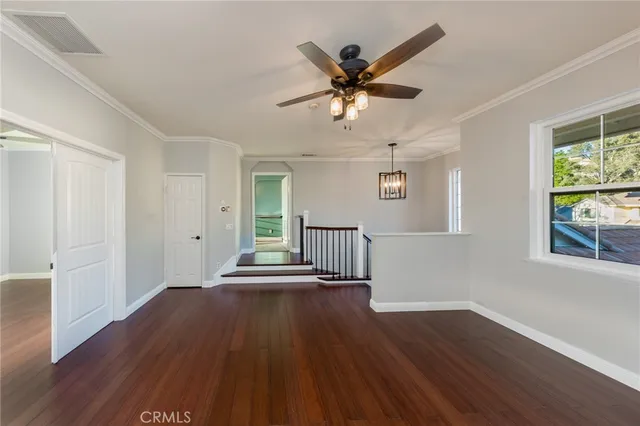 a view of a livingroom with wooden floor and a ceiling fan