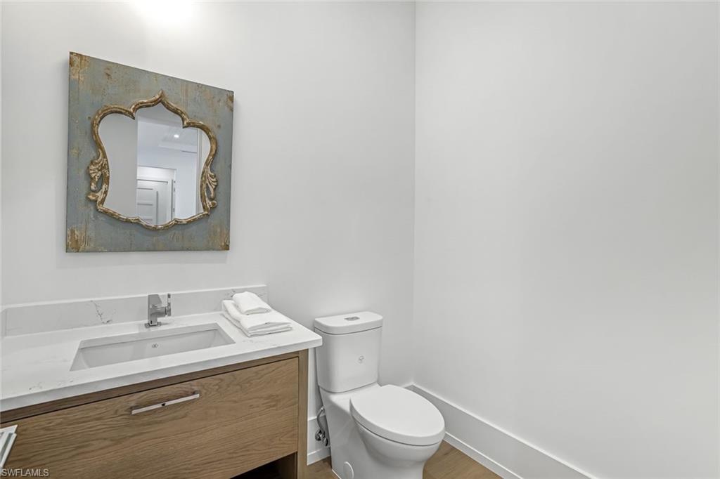 201 8th Street South, Unit 308 Naples, FL 34102 - Photo 19 of 28 a bathroom with a toilet sink vanity and mirror