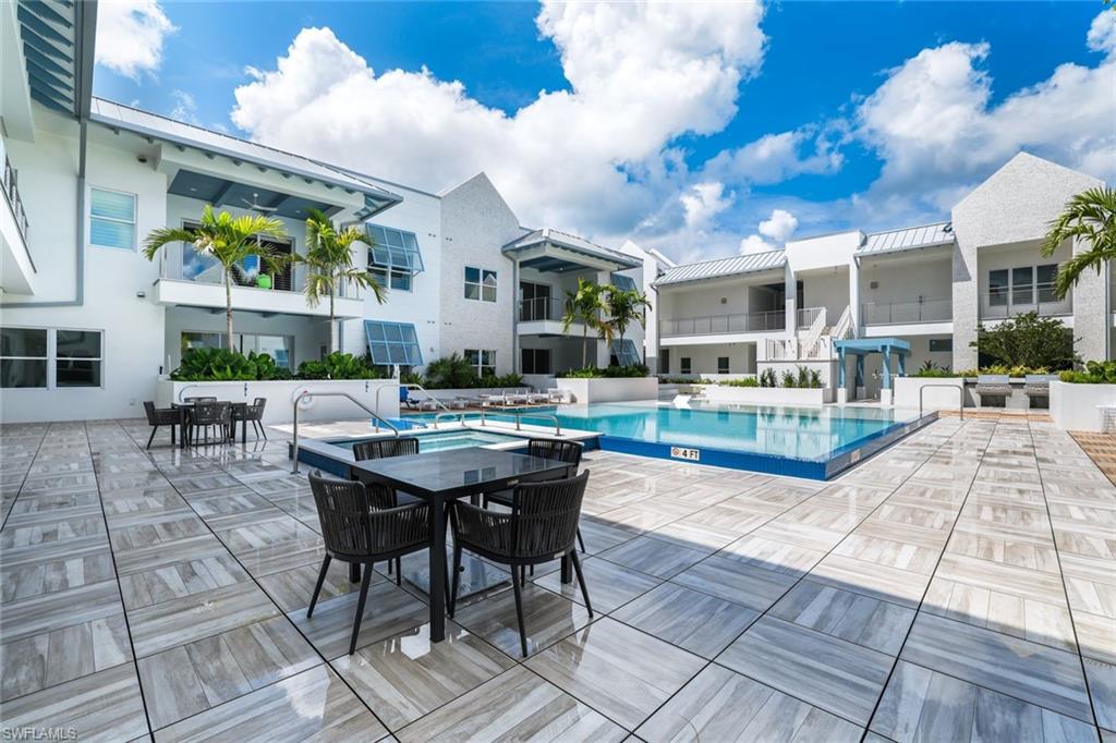 201 8th Street South, Unit 308 Naples, FL 34102 - Photo 24 of 28 a view of a patio with dining table and chairs with a yard