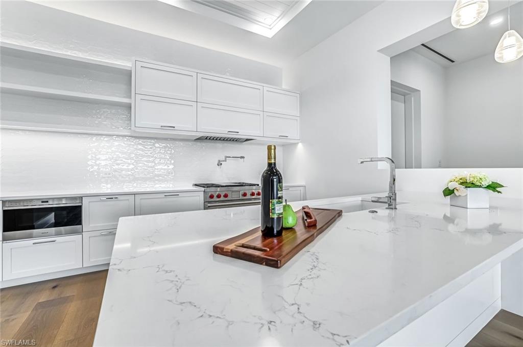 201 8th Street South, Unit 308 Naples, FL 34102 - Photo 5 of 28 a kitchen with kitchen island a white counter top space stove and cabinets