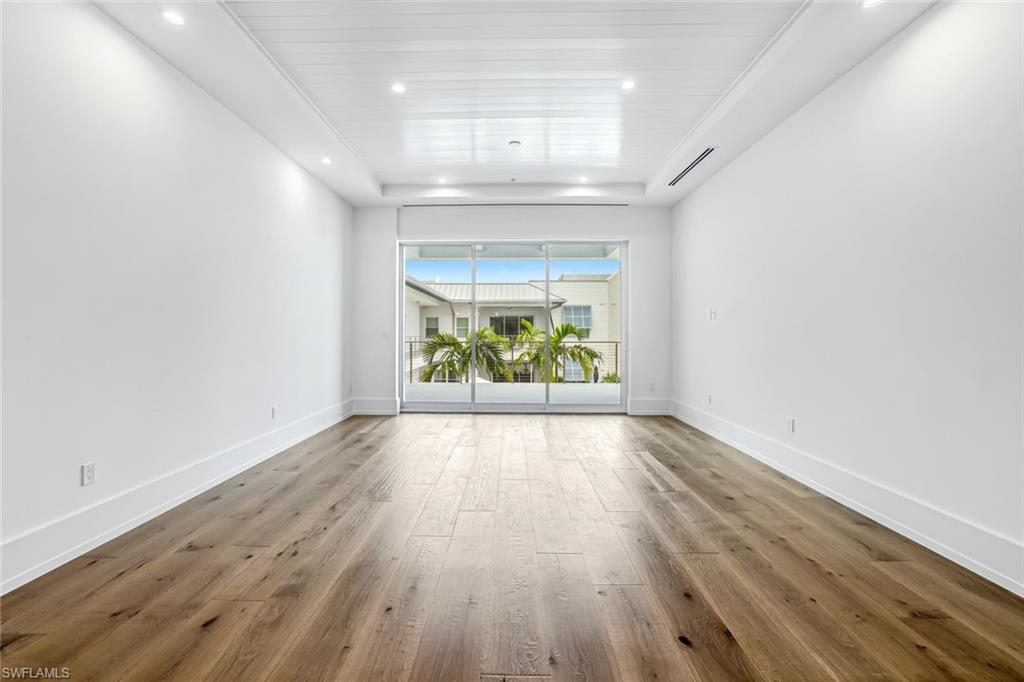 201 8th Street South, Unit 308 Naples, FL 34102 - Photo 8 of 28 an empty room with wooden floor and windows
