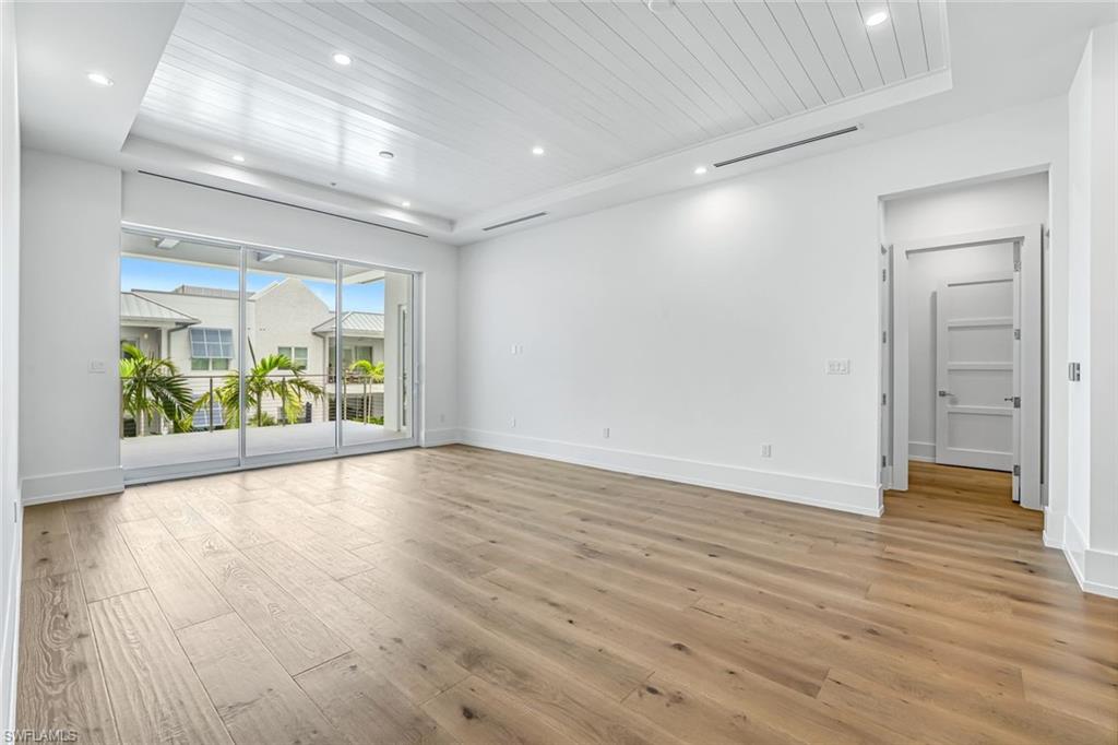 201 8th Street South, Unit 308 Naples, FL 34102 - Photo 9 of 28 an empty room with wooden floor and windows