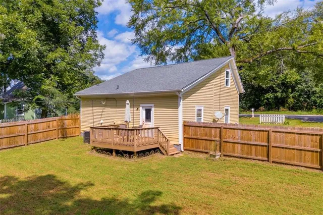 a view of backyard with swimming pool and seating space
