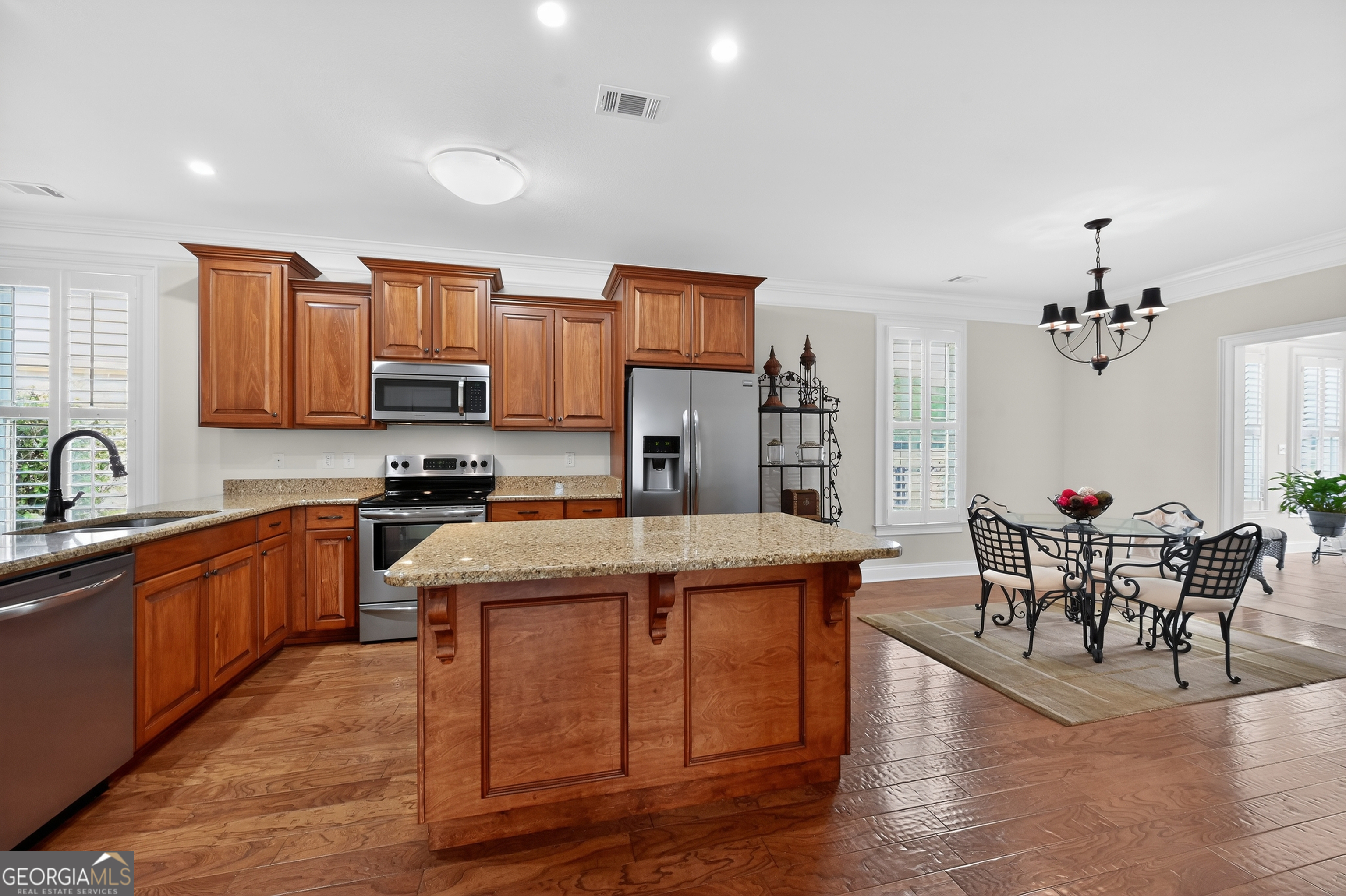1617 Red Oak Lane Albany, GA 31701 - Photo 11 of 36 a open kitchen with stainless steel appliances granite countertop a stove top oven a sink dishwasher a dining table and chairs with wooden floor