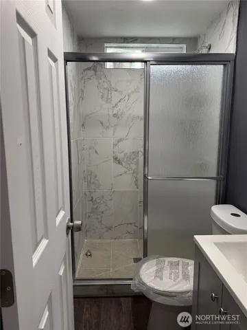 a bathroom with a shower a toilet and a sink