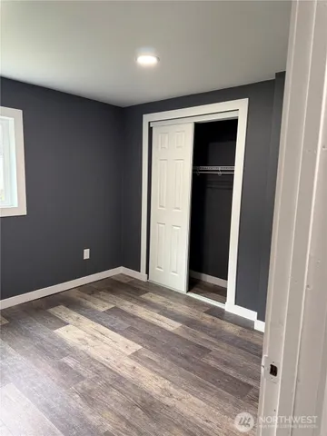 a view of an empty room with wooden floor