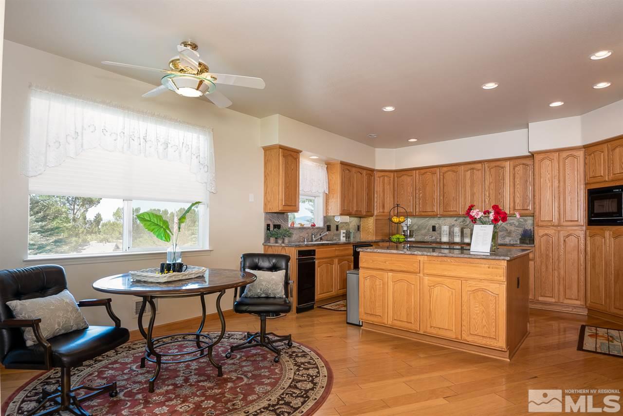 796 Foothill Road Gardnerville, NV 89460 - Photo 21 of 38 a kitchen with stainless steel appliances granite countertop sink stove and white cabinets with wooden floor