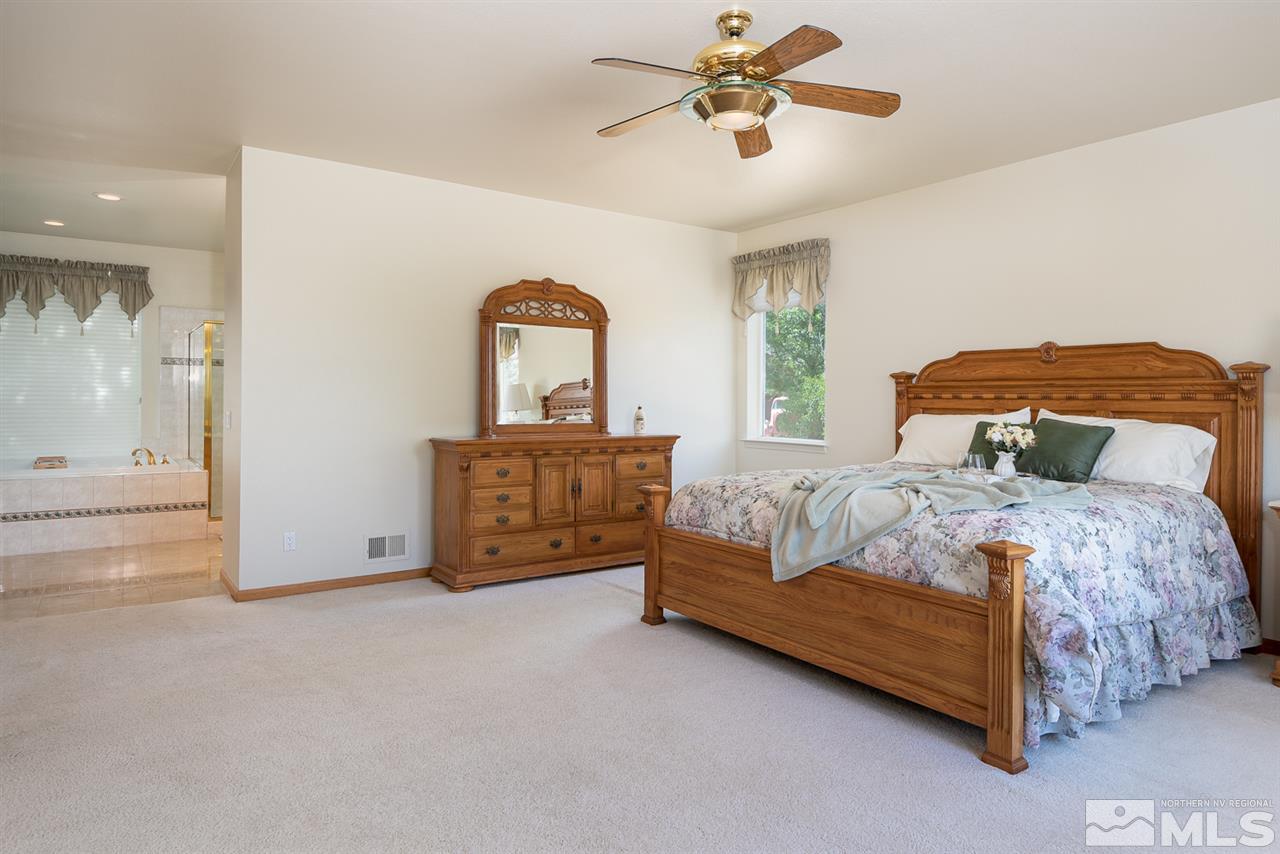 796 Foothill Road Gardnerville, NV 89460 - Photo 25 of 38 a bedroom with a bed and a chandelier