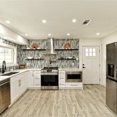 a kitchen with stainless steel appliances granite countertop a refrigerator and a stove top oven