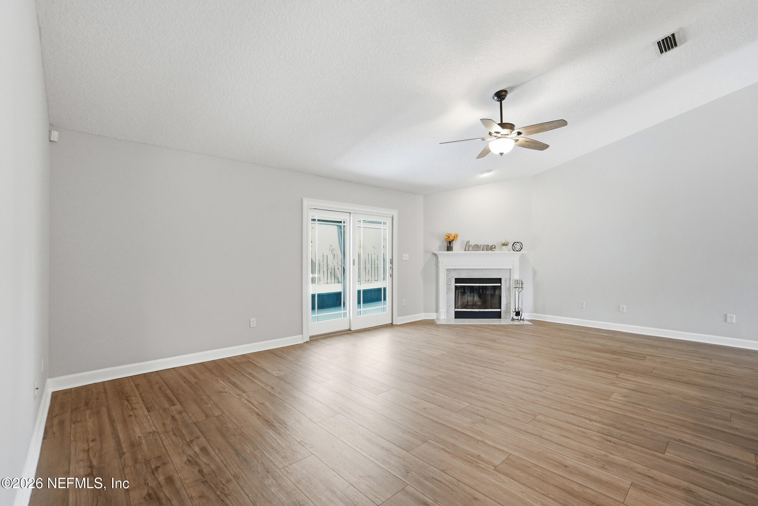 1194 Ardmore Street St. Augustine, FL 32092 - Photo 21 of 48 a view of a room with wooden floor a fireplace and windows