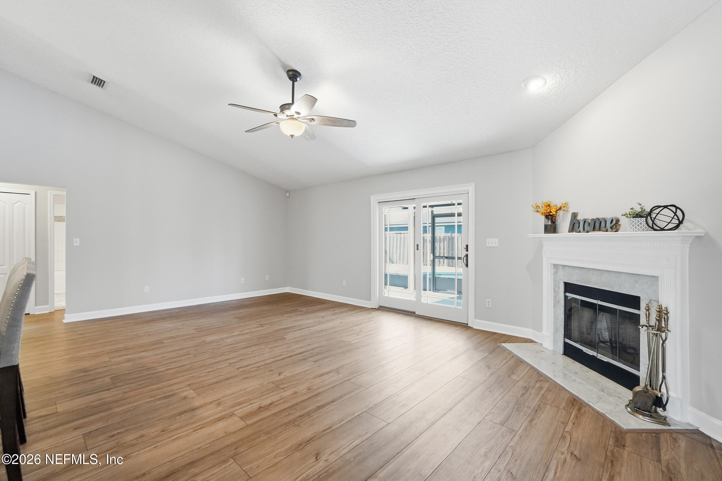 1194 Ardmore Street St. Augustine, FL 32092 - Photo 23 of 48 an empty room with wooden floor fireplace and windows
