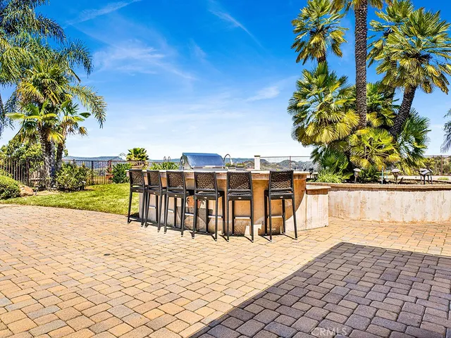a view of a patio with table and chairs and wooden fence
