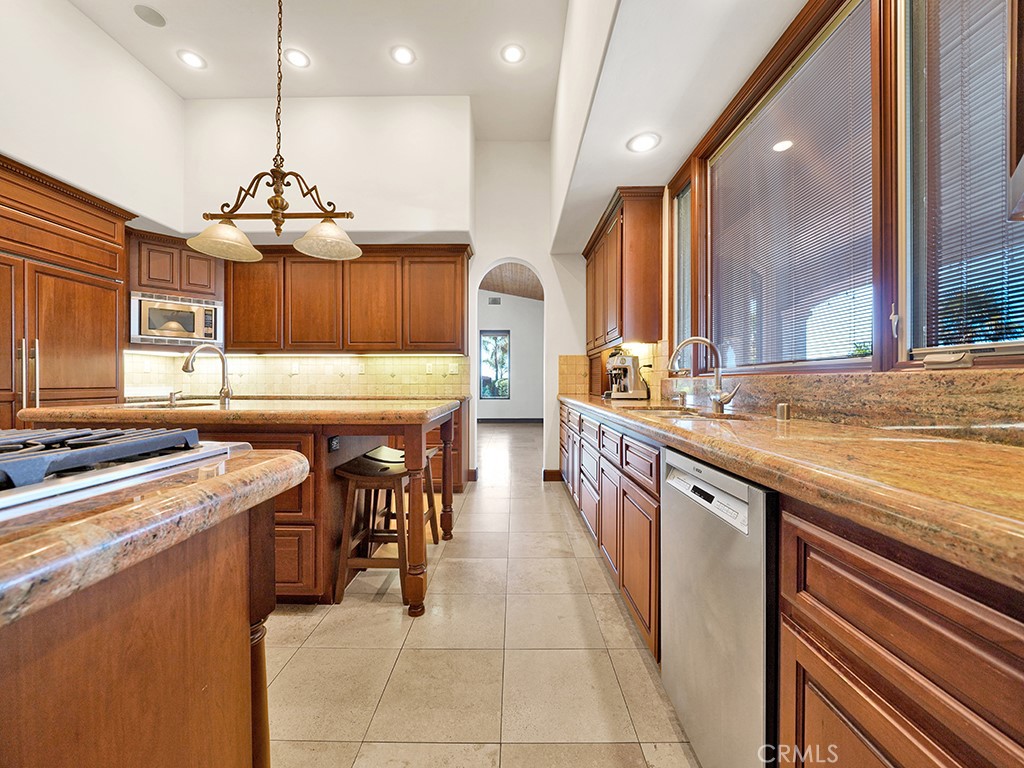 25900 Carancho Road Temecula, CA 92590 - Photo 44 of 58 a kitchen with stainless steel appliances granite countertop table chairs sink and cabinets
