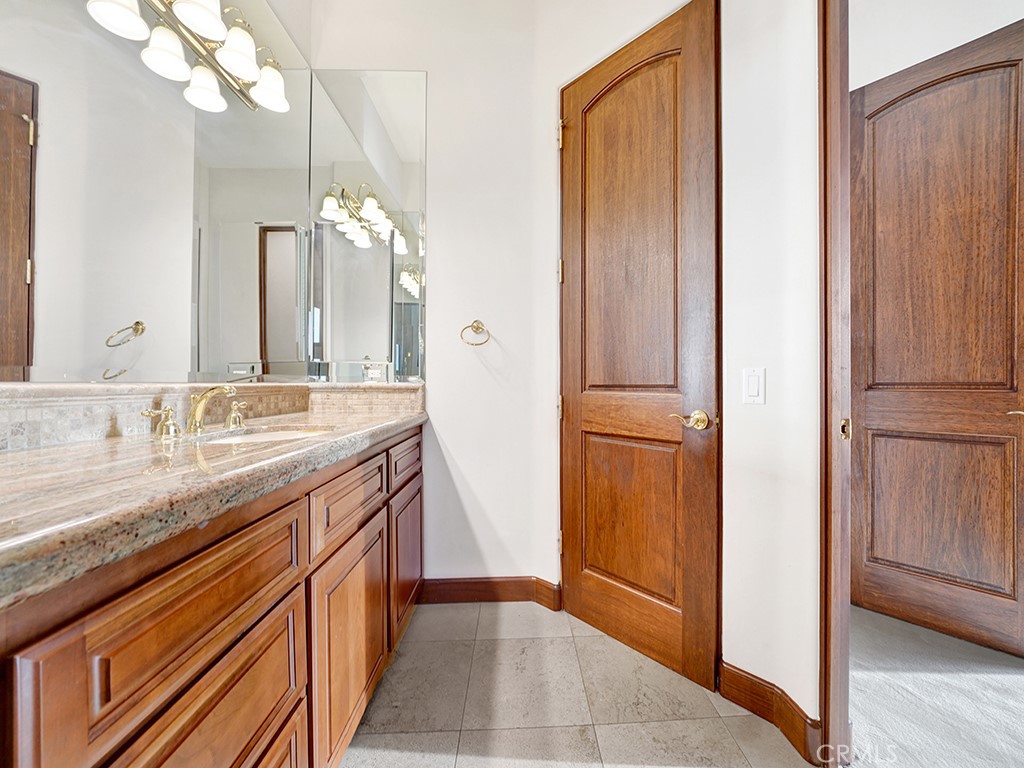 25900 Carancho Road Temecula, CA 92590 - Photo 54 of 58 a bathroom with a granite countertop sink and a mirror
