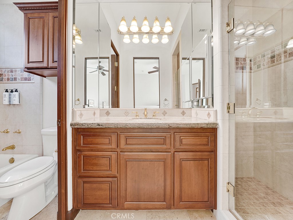 25900 Carancho Road Temecula, CA 92590 - Photo 56 of 58 a bathroom with a granite countertop sink a mirror and a vanity