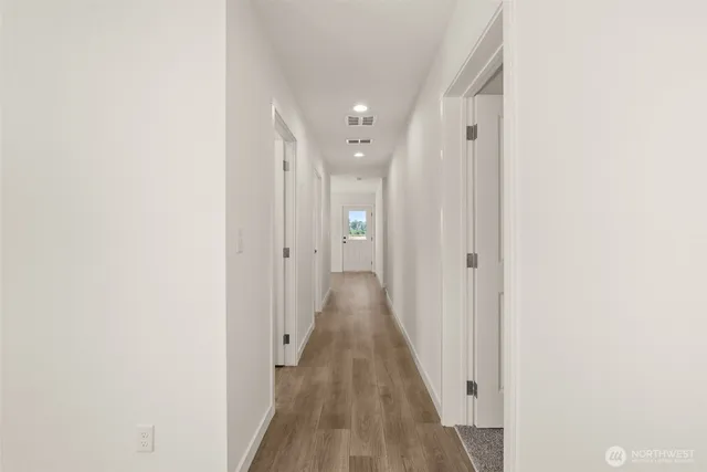 a view of a hallway with wooden floor