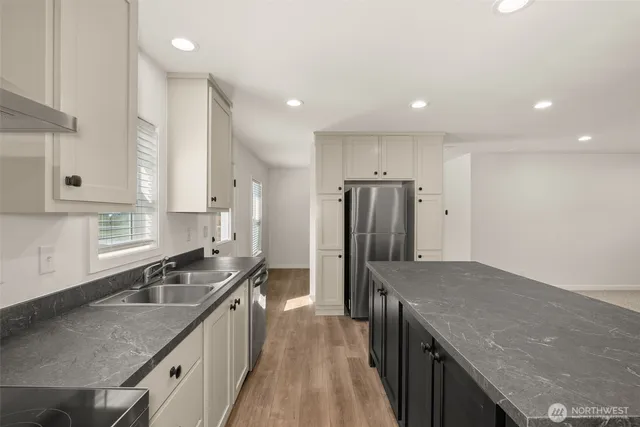 a kitchen with stainless steel appliances granite countertop a sink a stove and a refrigerator