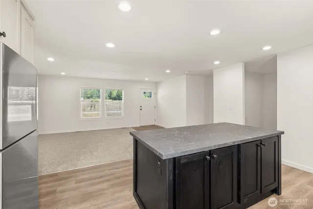 a kitchen with a wooden floor and cabinets
