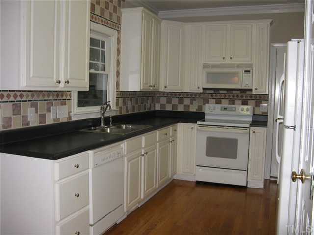 Great working kitchen with custom backsplash, nice size pantry, dishwasher, disposal, smooth top, self cleaning range, microwave and refrigerator.