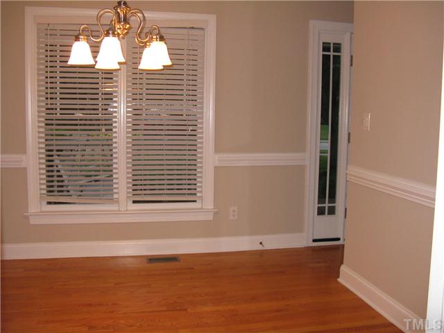 209 Rushing Wind Way Apex, NC 27502 - Photo 8 of 16 Formal dining room with newly stained hardwood flooring, crown and chair rail moulding and beautiful butler door.