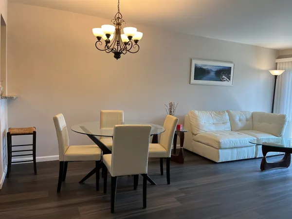 a view of a dining room with furniture wooden floor and a chandelier