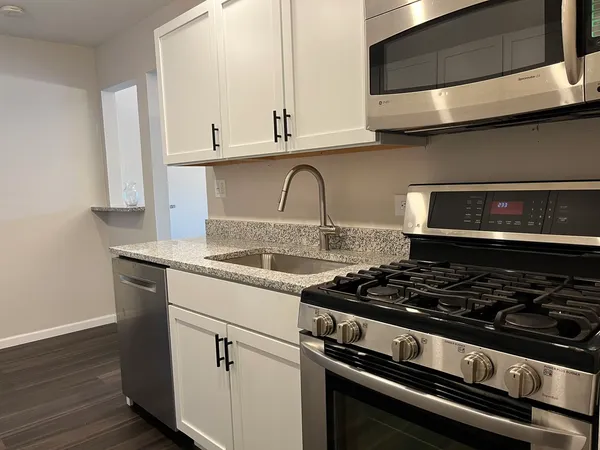 a stove top oven sitting inside of a kitchen