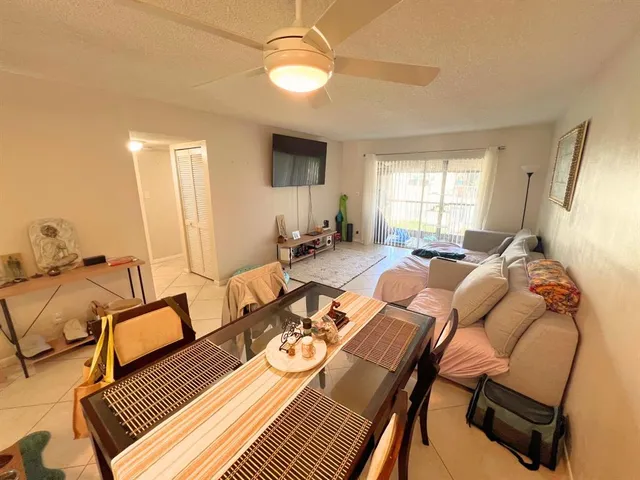 a living room with furniture a flat screen tv and windows